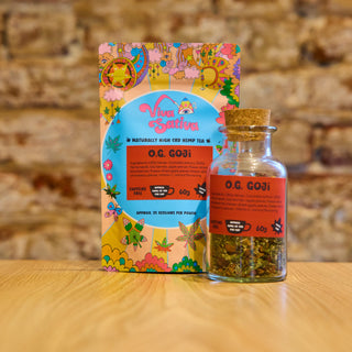 Viva Sativa O.G. Goji CBDa hemp tea in a glass jar with cork lid, featuring a loose leaf blend of hemp, goji berries and fruit, alongside its colourful packaging.
